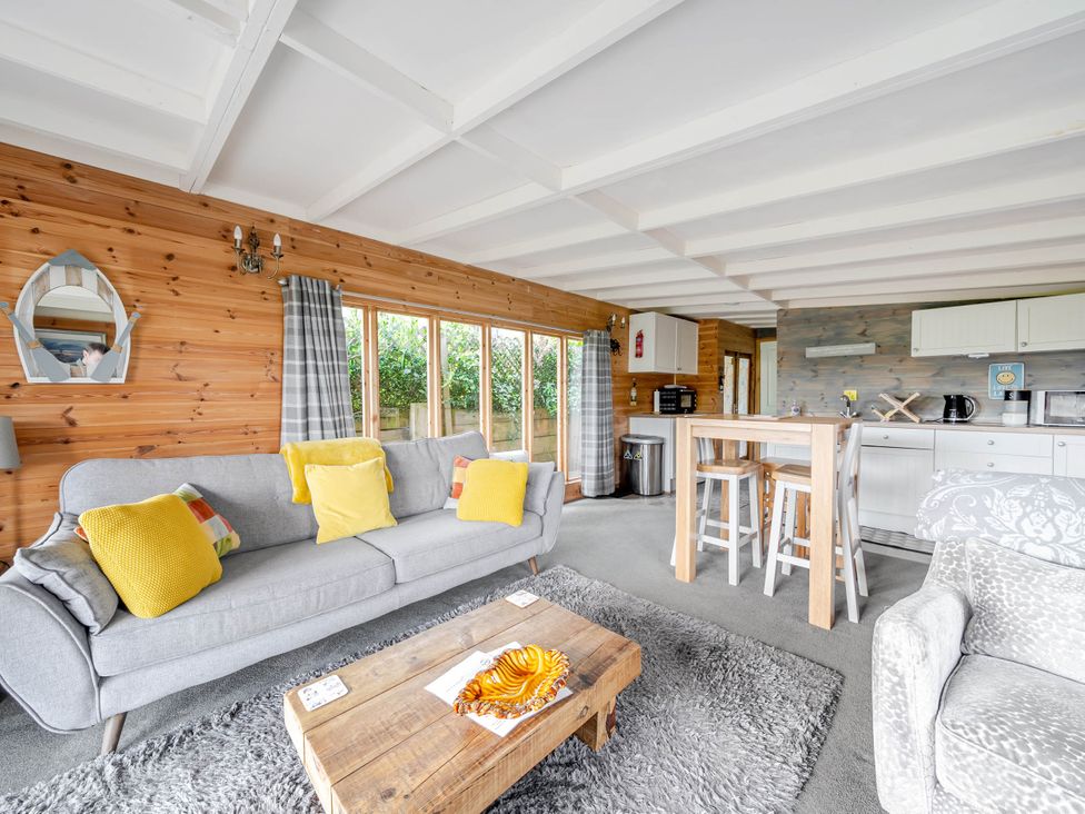 A living room with a sofa and a dining area at Peaceful Cabin in Skegby -Sleeps2- Fire Pit