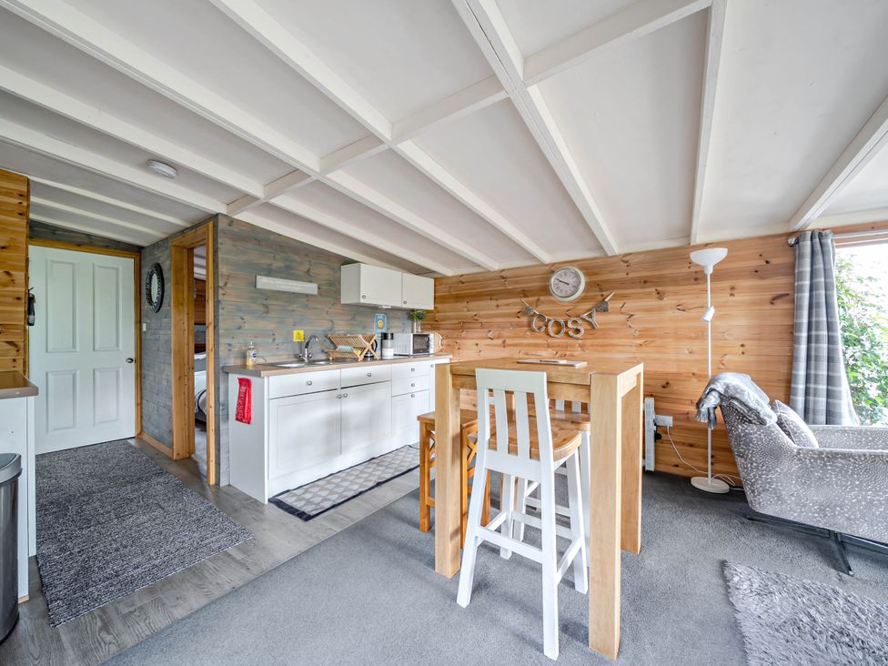 A living room with a kitchen area and dining table at Peaceful Cabin in Skegby -Sleeps2- Fire Pit, Stanton Hill