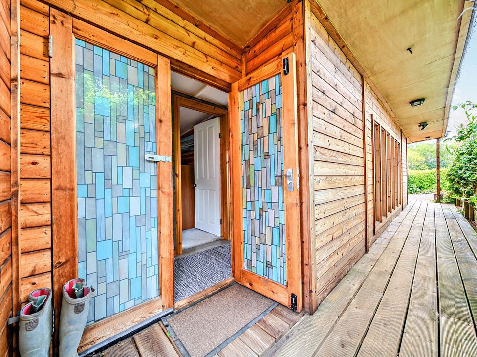 An entrance with glass doors and wooden walls at Peaceful Cabin in Skegby -Sleeps2- Fire Pit Stanton Hill