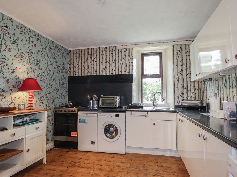 A kitchen with appliances and a window at Keepers Cottage in New Deer