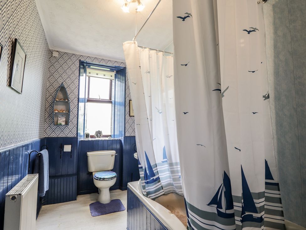 A bathroom with a bathtub and toilet at Keepers Cottage in New Deer