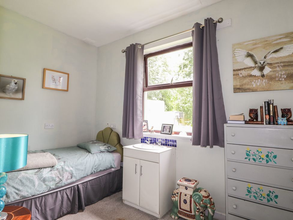 A bedroom with a bed and a window at Keepers Cottage in New Deer