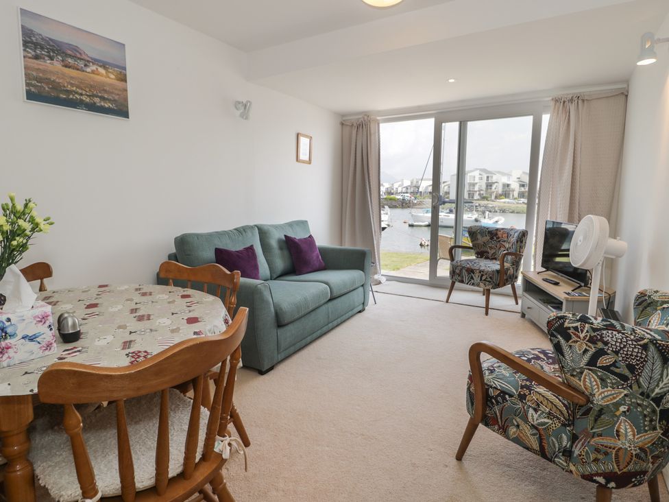 A living room with a sofa and dining table at Harbourside in Porthmadog