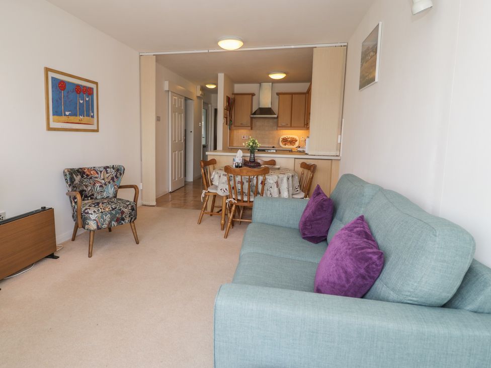 A living room with a sofa and dining area at Harbourside in Porthmadog