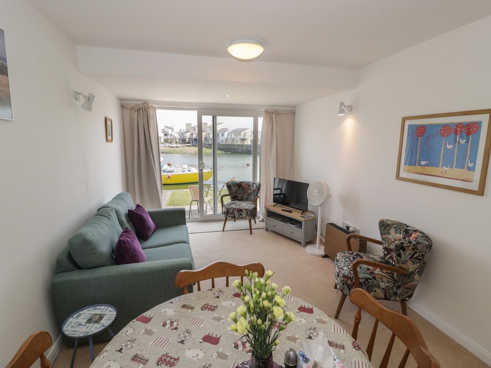 A living room with a couch and dining table at Harbourside in Porthmadog