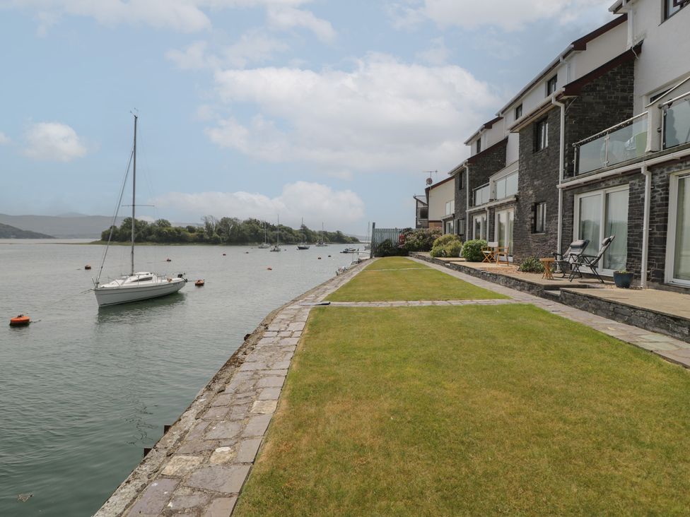 An outdoor view of a lawn and water with boats at Harbourside in Porthmadog