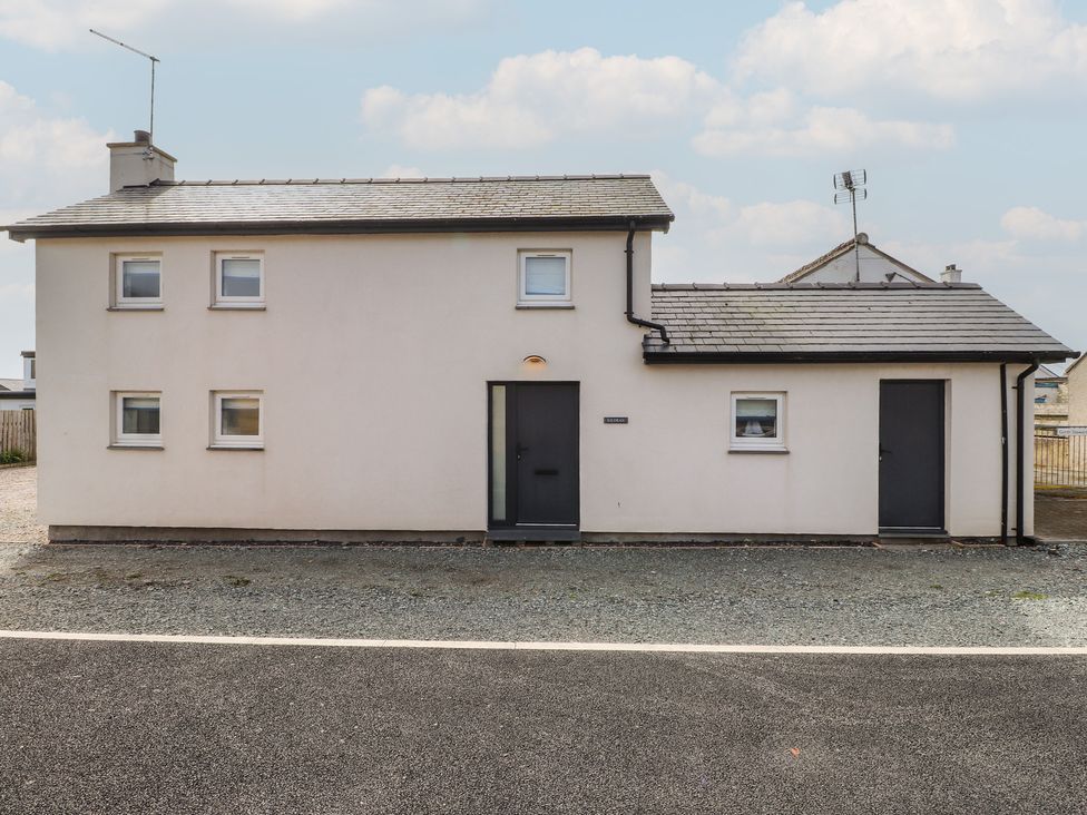 A house with two doors and multiple windows at Kiloran in Rhosneigr