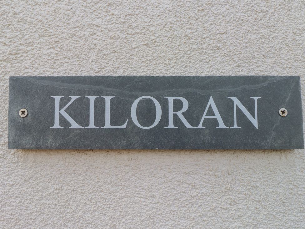 A nameplate with Kiloran displayed on a textured wall