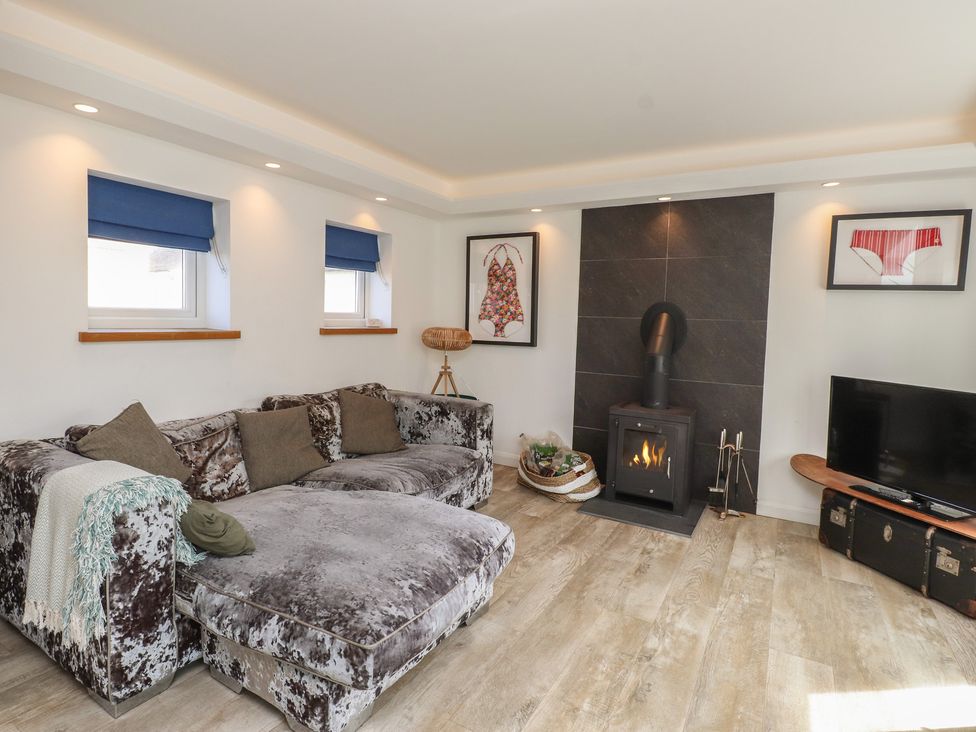 A living room with a sofa and fireplace at Kiloran in Rhosneigr