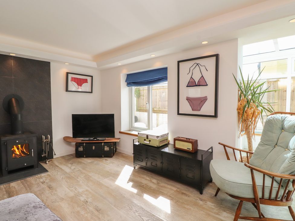 A living room with a television and artwork at Kiloran in Rhosneigr