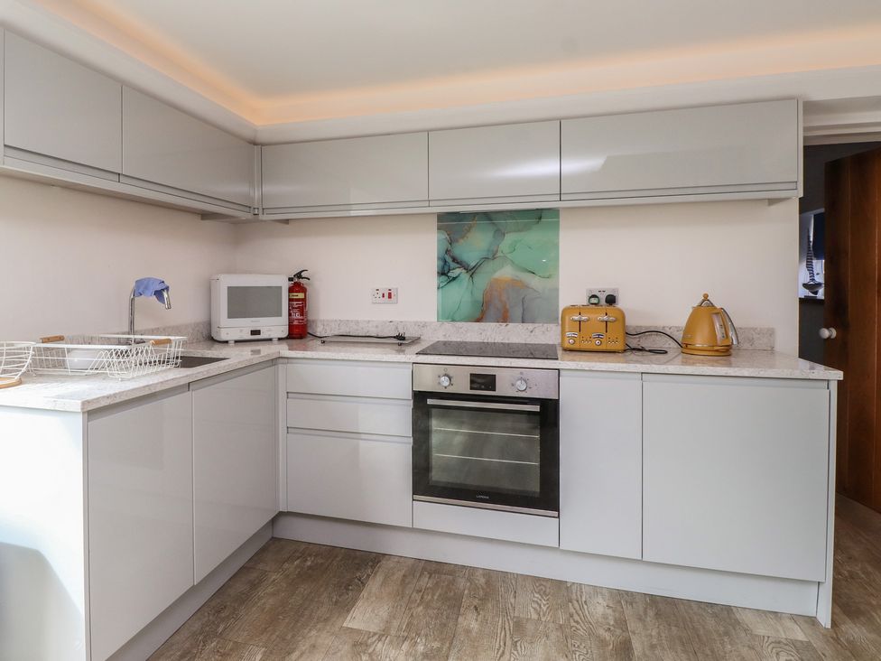 A kitchen with modern cabinets and appliances at Kiloran in Rhosneigr