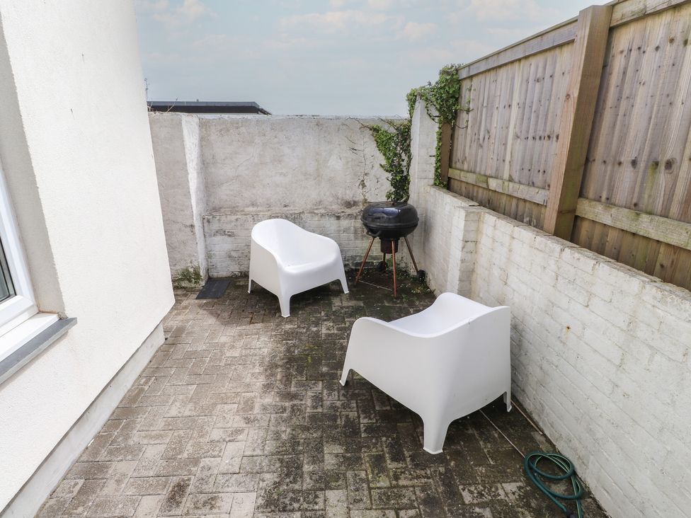 An outdoor area with two chairs and a barbecue at Kiloran in Rhosneigr