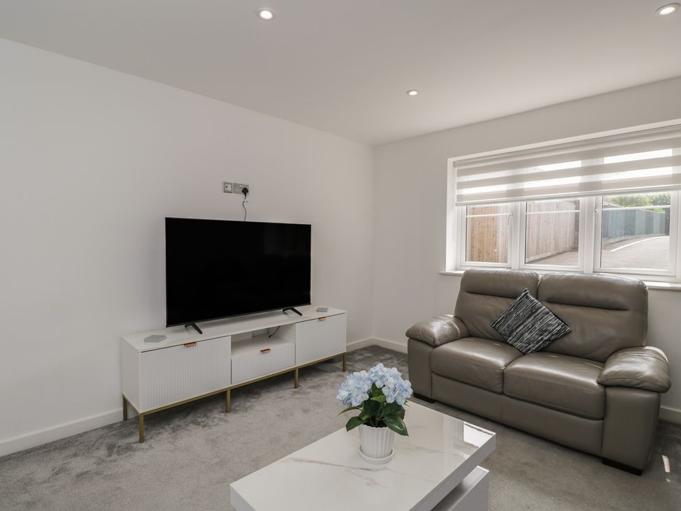 A living room with a television and a sofa at 1 Brunel Court