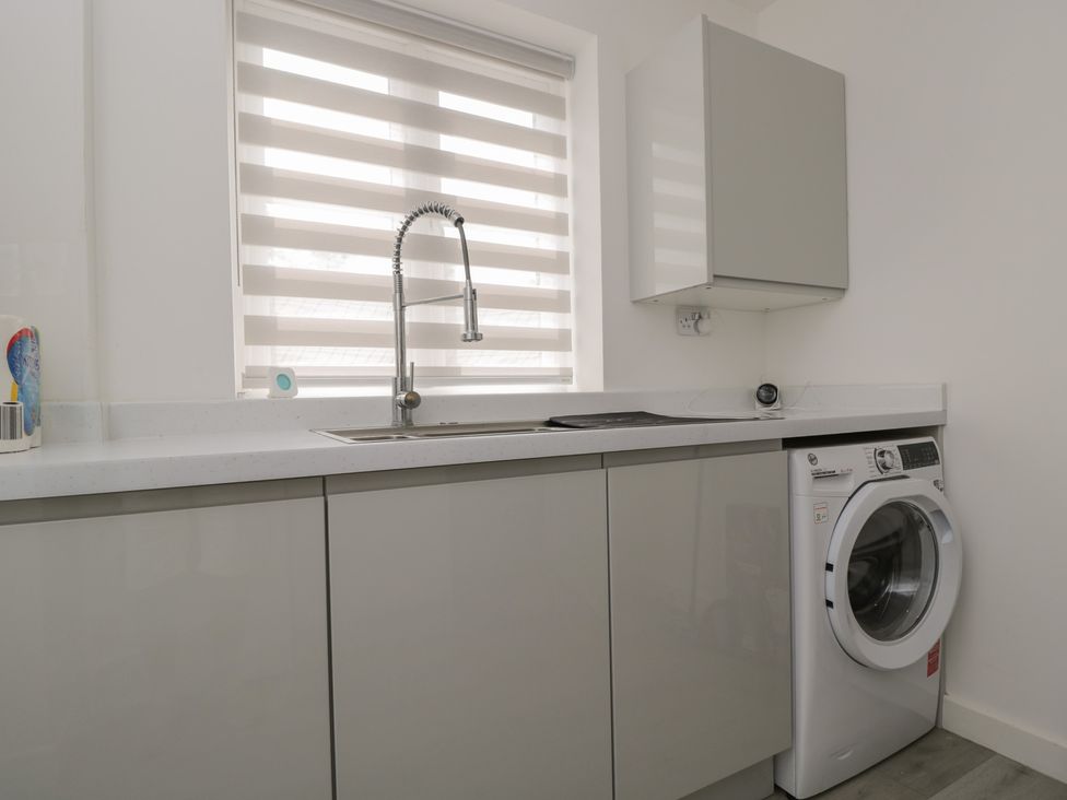A laundry room with a washing machine and a sink at 1 Brunel Court