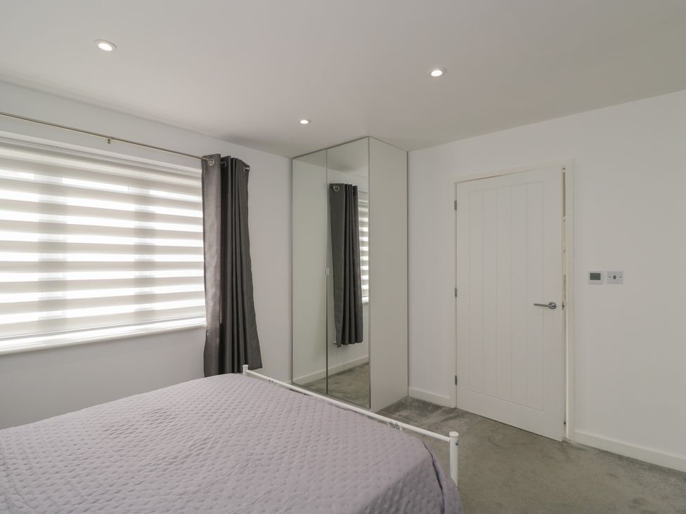 A bedroom with a bed and mirror at 1 Brunel Court