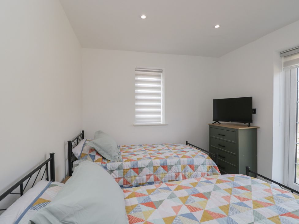 A bedroom with two beds and a television at 1 Brunel  Court