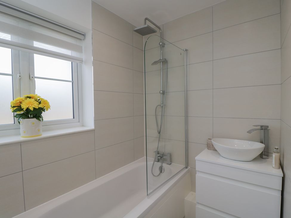 A bathroom with a bathtub, shower, and sink at 1 Brunel Court