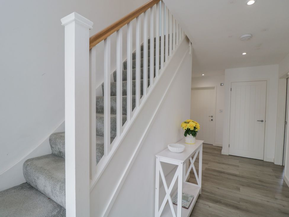 A hallway with a staircase and table at 1 Brunel Court