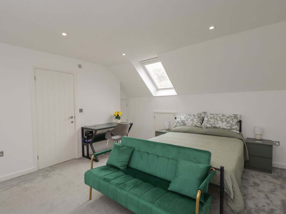 A bedroom with a bed, sofa, desk, and chair at 1 Brunel Court