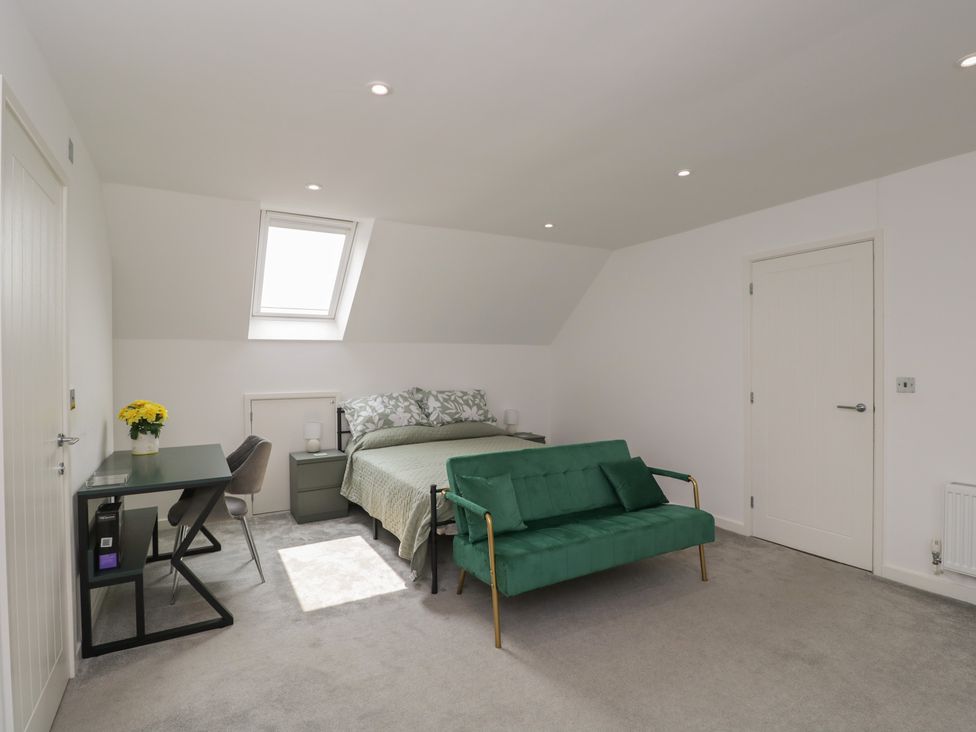 A bedroom with a bed, desk and sofa at 1 Brunel Court