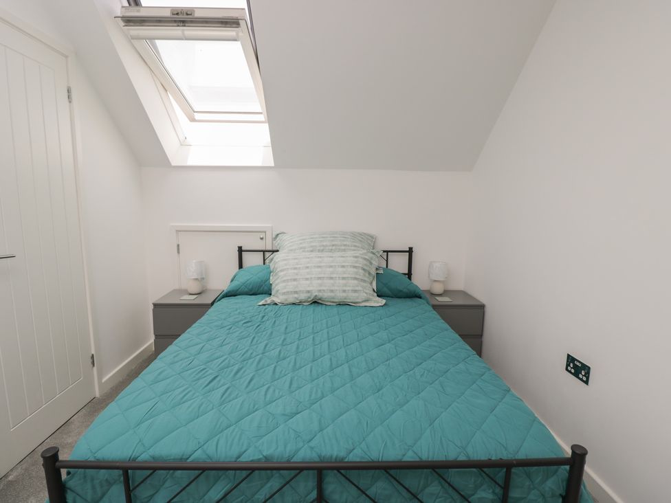 A bedroom with a bed and bedside tables at 1 Brunel Court