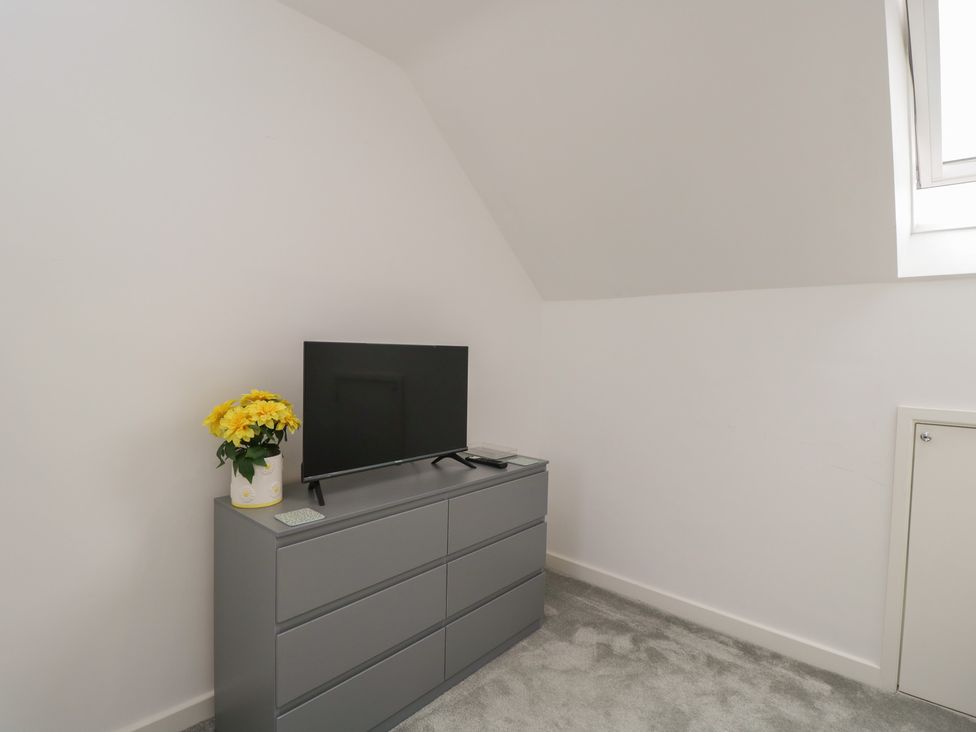 A bedroom with a television and a dresser at 1 Brunel Court
