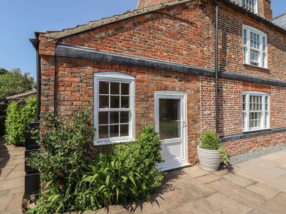 An exterior view of a brick house with a door and window at Ivy House near Louth