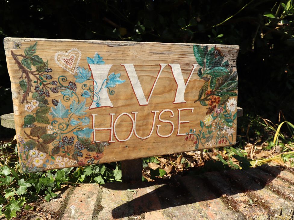 A wooden sign that reads 'IVY HOUSE' with floral designs near Louth