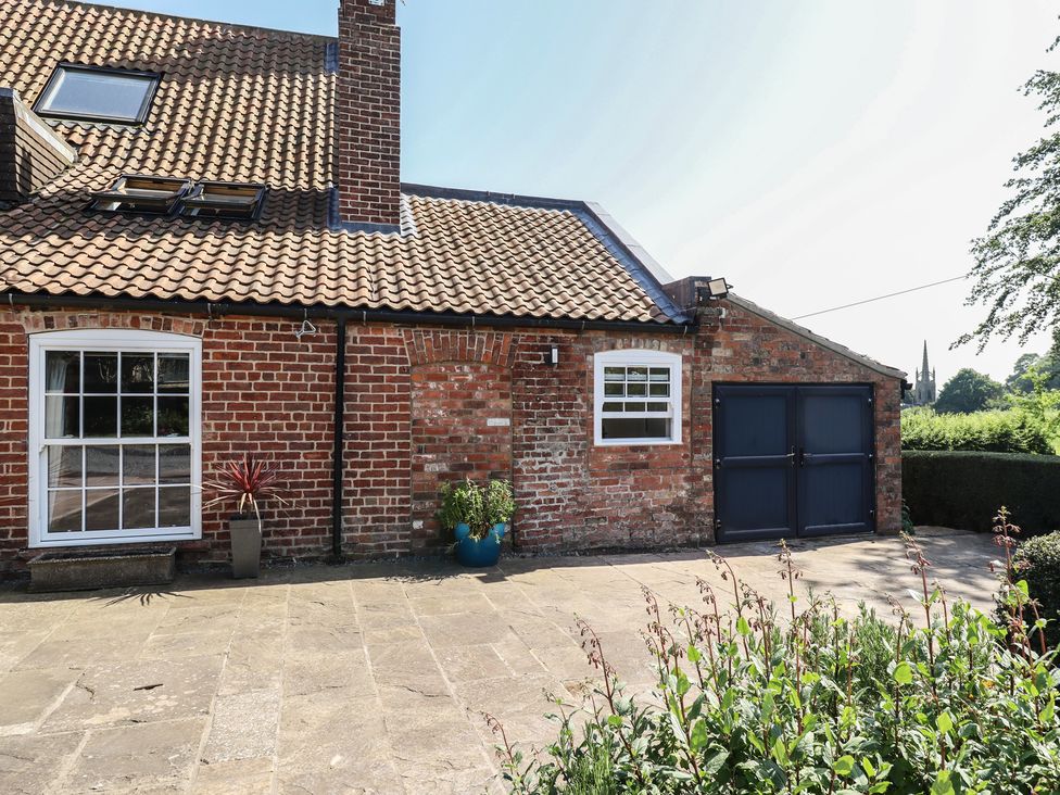 An outdoor view of a brick building with a garage door at Ivy House near Louth