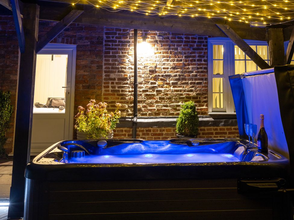 A hot tub with LED lights and plants at Ivy House near Louth