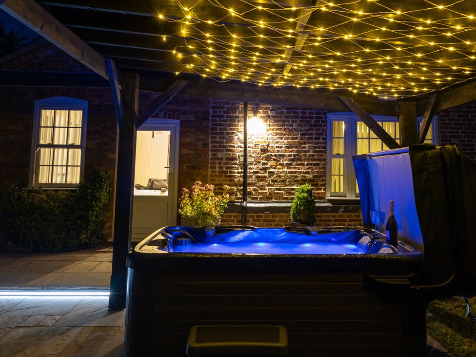 A hot tub with flowers near a building at Ivy House near Louth