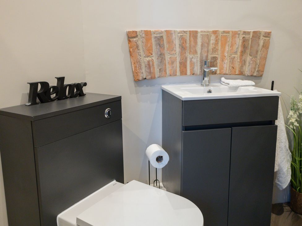A bathroom with a sink, toilet and cabinetry at Ivy House near Louth