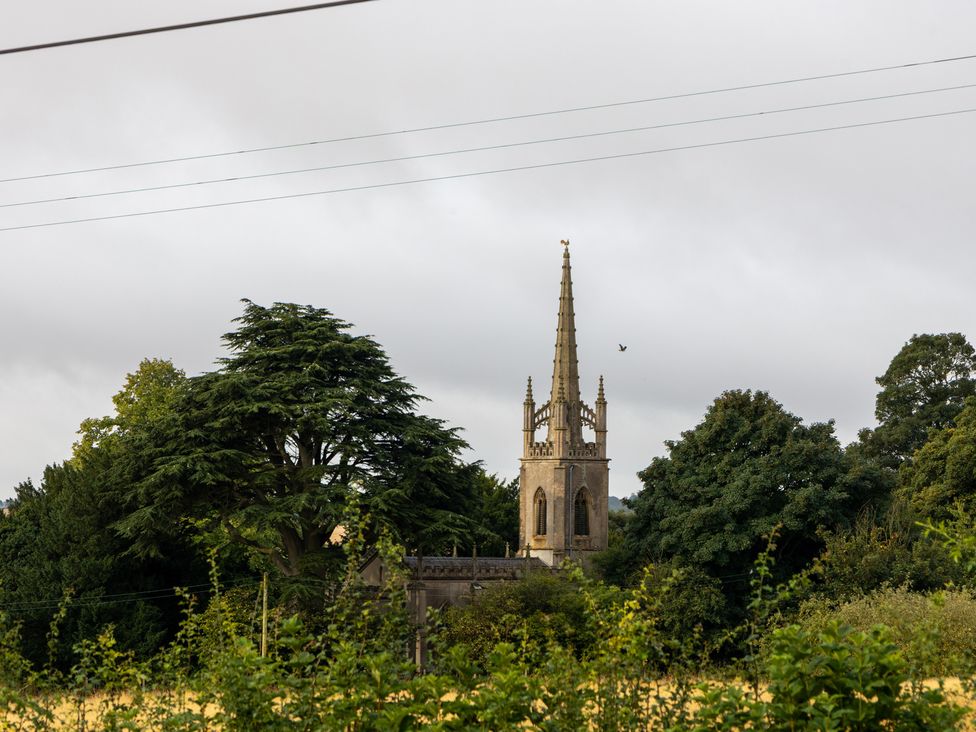 A church with a spire and trees at Ivy House near Louth