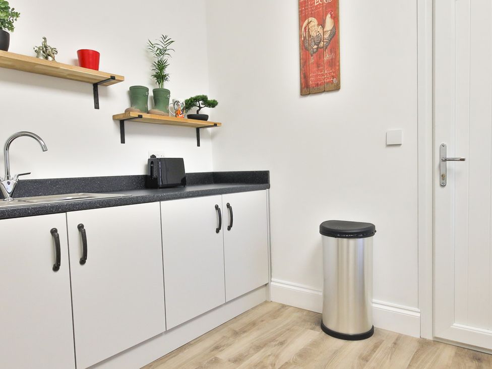 A kitchen with a sink and cupboard at The Groom's Cottage, at Ivy House near Louth