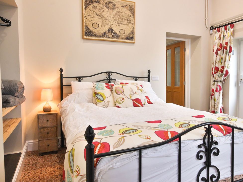 A bedroom with a bed and bedside lamp at The Groom's Cottage, at Ivy House near Louth