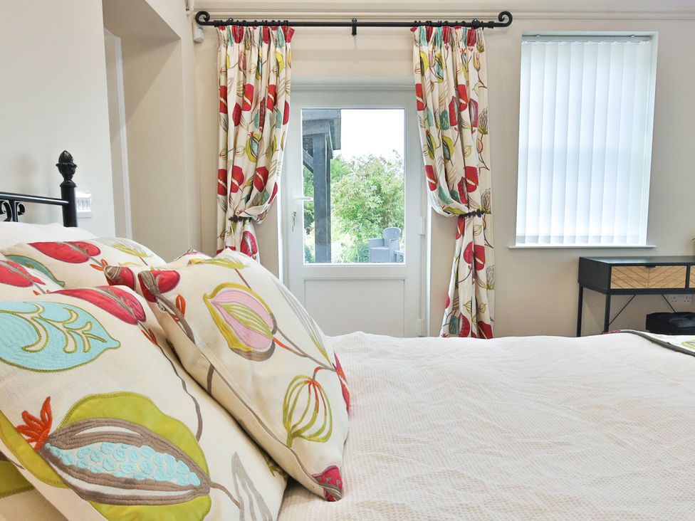 A bedroom with a bed and curtains at The Groom's Cottage, at Ivy House near Louth
