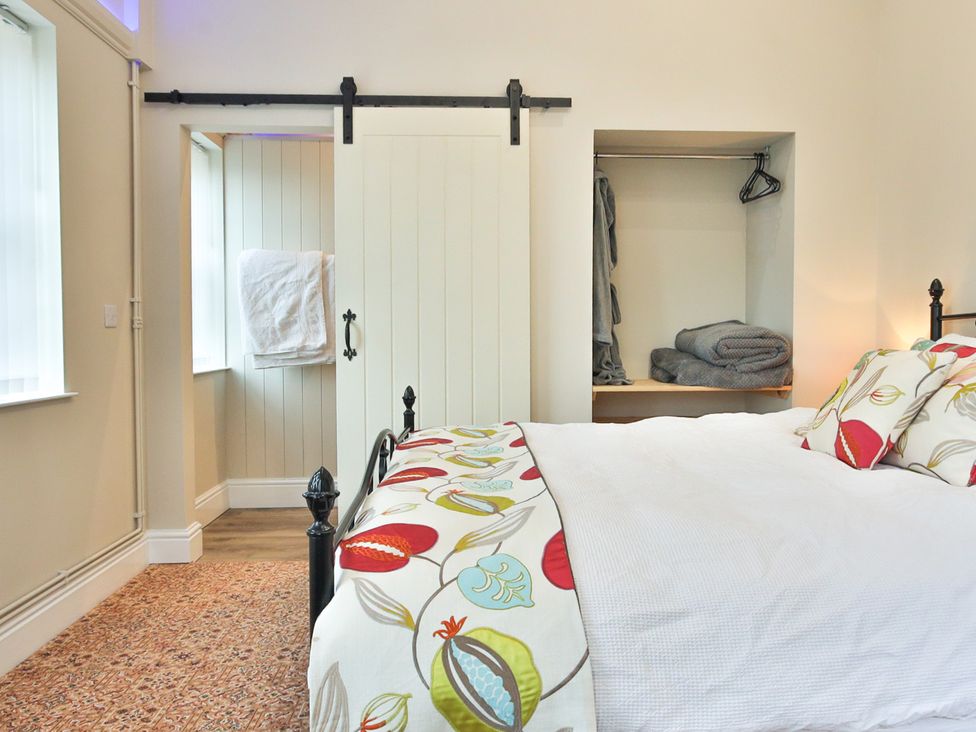 A bedroom with a bed and closet at The Groom's Cottage, at Ivy House near Louth