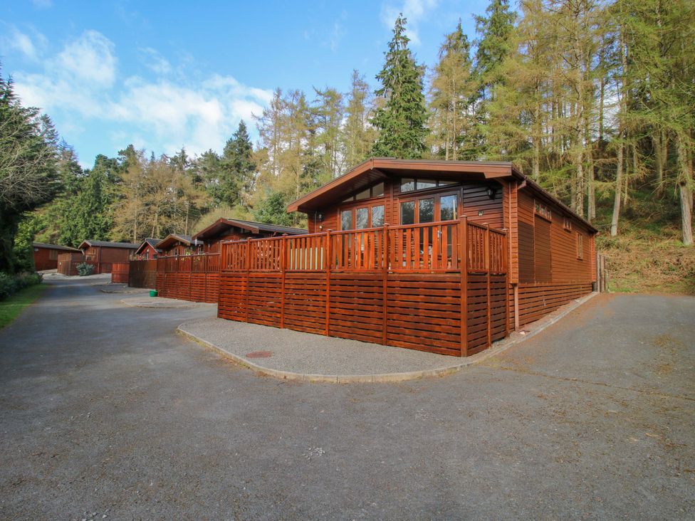 A log cabin with decking and surrounding trees at No.14 Astbury Falls Luxury Retreat in Bridgnorth