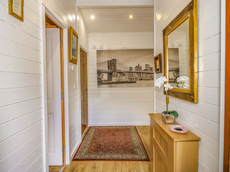 A hallway with a table and mirror at No.14 Astbury Falls Luxury Retreat in Bridgnorth