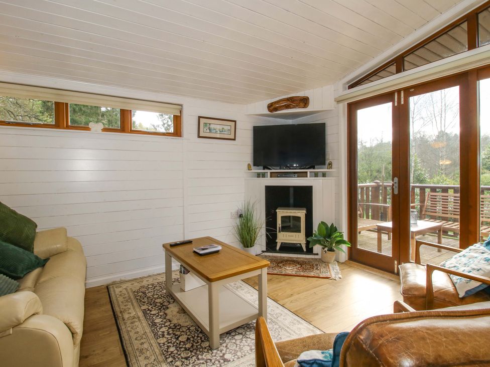A living room with a couch, coffee table, and television at No.14 Astbury Falls Luxury Retreat in Bridgnorth