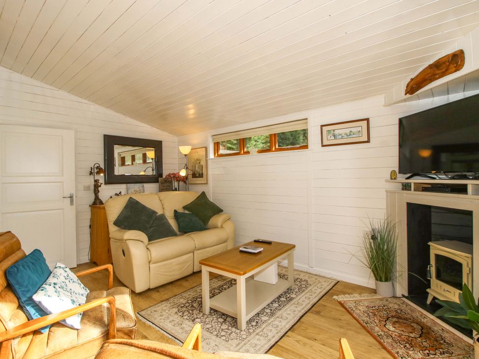 A living room with a sofa and television at No.14 Astbury Falls Luxury Retreat in Bridgnorth