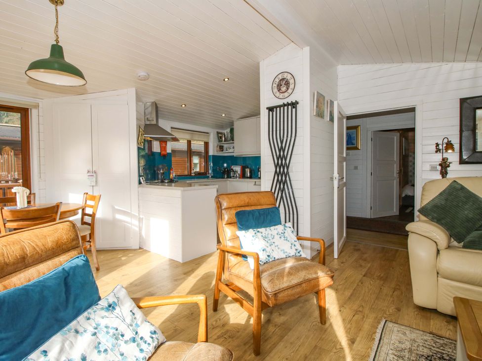 A living room with chairs and a kitchen area at No.14 Astbury Falls Luxury Retreat in Bridgnorth