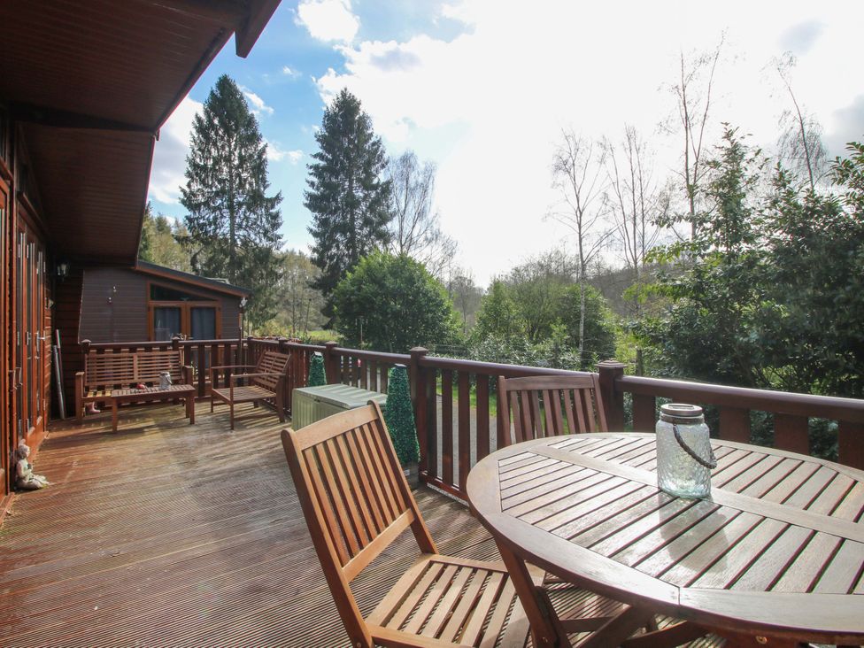A deck with wooden table and chairs at No.14 Astbury Falls Luxury Retreat in Bridgnorth