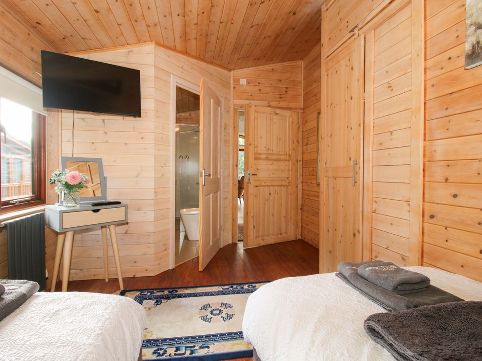 A bedroom with twin beds and a television at No.14 Astbury Falls Luxury Retreat Bridgnorth