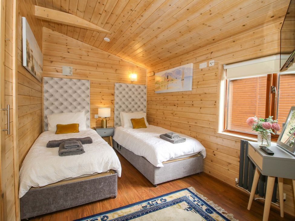 A bedroom with two beds and a window at No.14 Astbury Falls Luxury Retreat in Bridgnorth