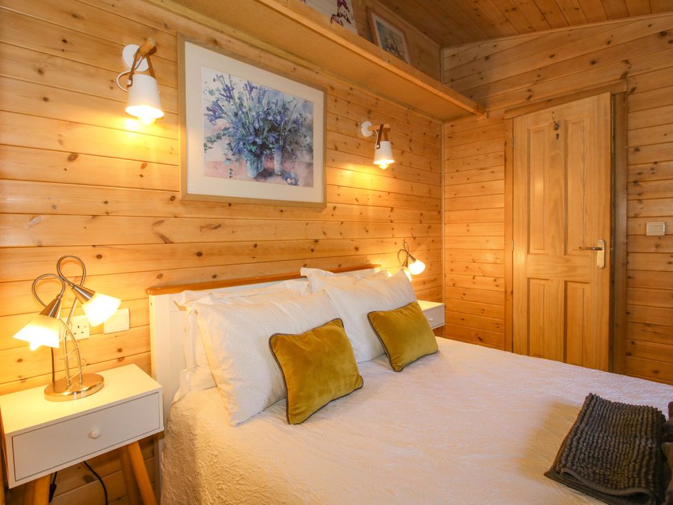 A bedroom with wooden walls and a bed at No.14 Astbury Falls Luxury Retreat in Bridgnorth