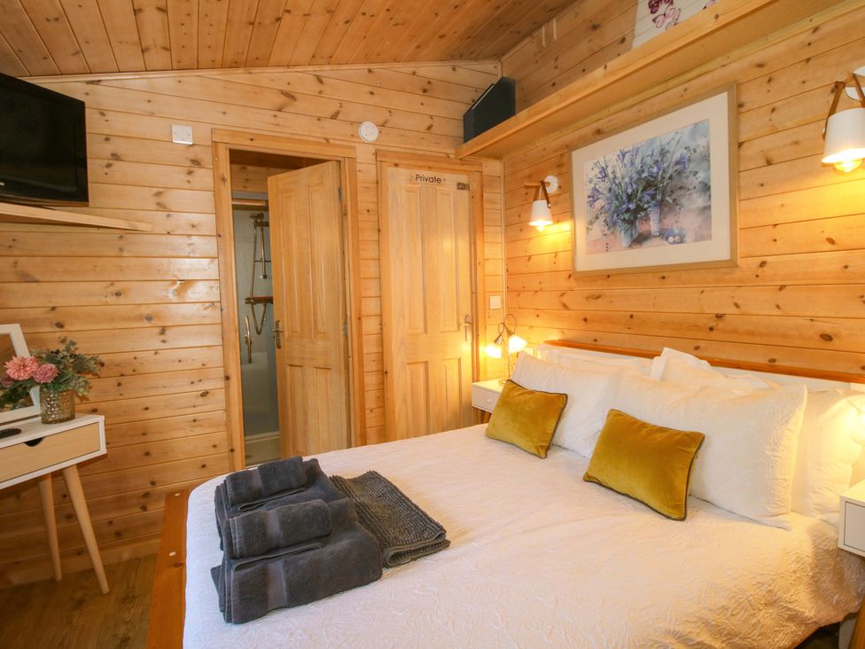 A bedroom with a bed and television at No.14 Astbury Falls Luxury Retreat Bridgnorth