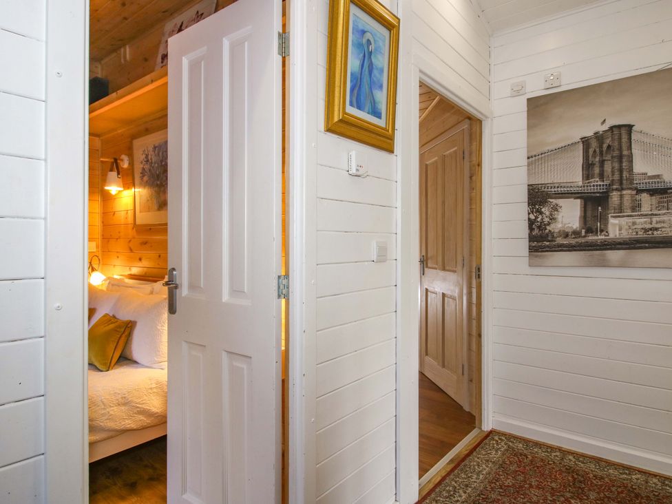 A view of a bedroom with a bed and wall art at No.14 Astbury Falls Luxury Retreat in Bridgnorth