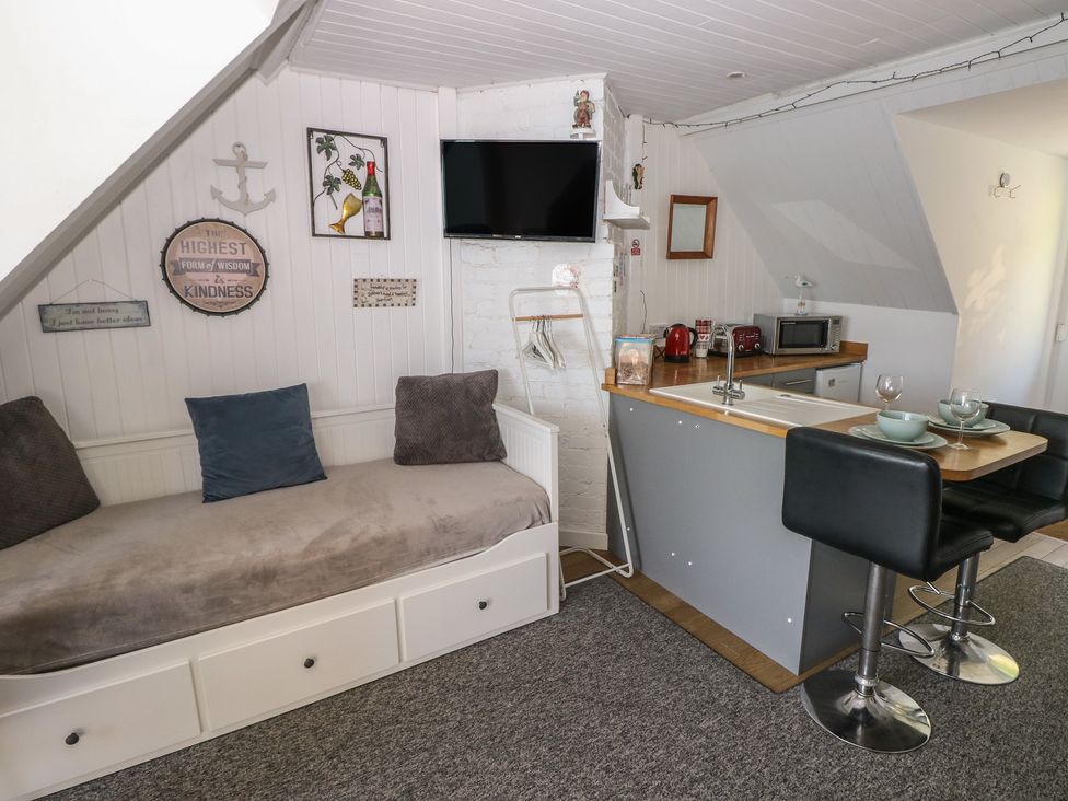 A studio with a sofa and kitchen area at Seaside Steps in Goodwick