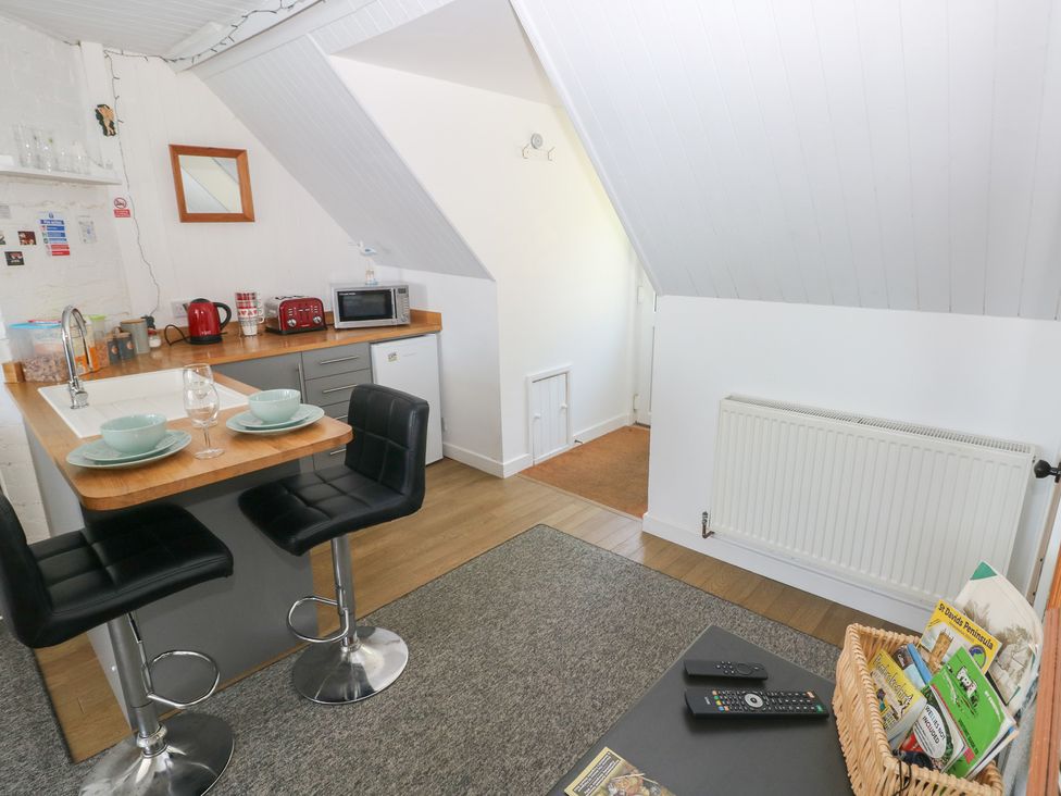 A kitchen with counter stools and appliances at Seaside Steps in Goodwick
